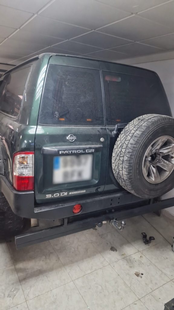 Vista trasera de Nissan Patrol GR con paragolpes, rueda de repuesto y enganche